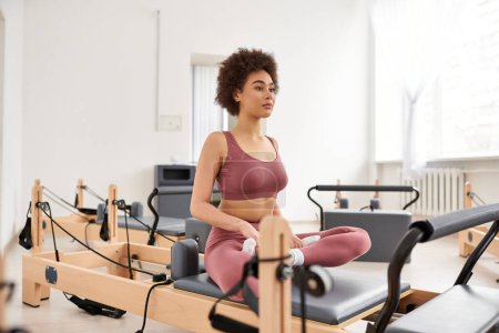 A sporty woman practices pilates in a stylish room.