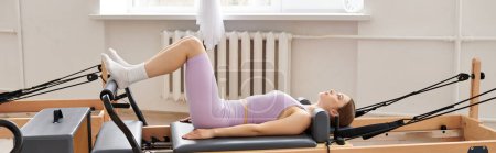 Photo for A woman performs pilates in a serene room. - Royalty Free Image