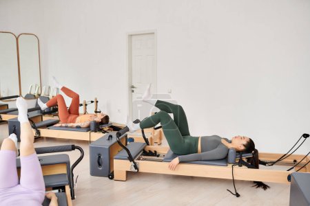 Attractive women engaging in a pilates workout at the gym.