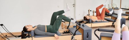 Téléchargez les photos : Femmes séduisantes s'engageant dans un entraînement de pilates à la salle de gym. - en image libre de droit