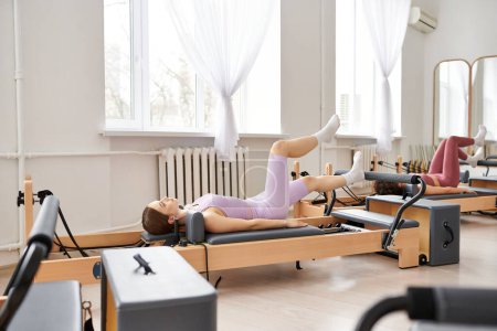Téléchargez les photos : Jolies femmes se livrant à un entraînement de pilates à la salle de gym. - en image libre de droit