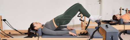 Photo for Fit woman exercising during a Pilates session. - Royalty Free Image