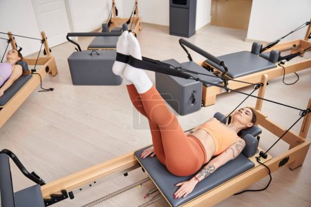 Photo for Attractive woman on a pilates lesson, next to friend. - Royalty Free Image