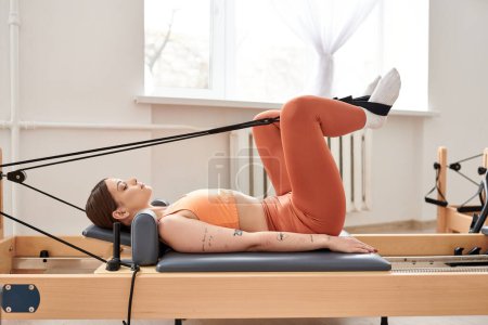 Téléchargez les photos : Femme active en haut orange faisant de l'exercice activement. - en image libre de droit