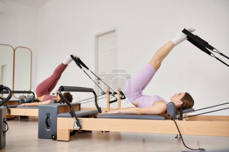 Sporty woman gracefully pivoting on a rowing machine during pilates lesson.