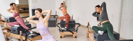 Eine Gruppe ziemlich sportlicher Frauen, die Yoga praktizieren, posiert in einem lebendigen Studio.