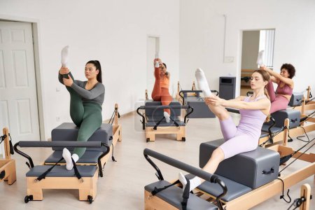 Femmes actives engagées dans un cours de Pilates, axées sur les exercices d'étirement et de renforcement.