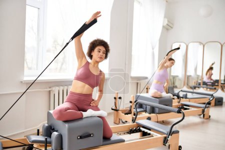 Good looking women engage in a pilates class, focusing on flexibility and core strength.