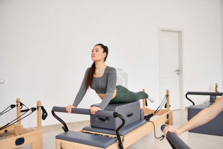 Appealing woman exercising during a pilates lesson.