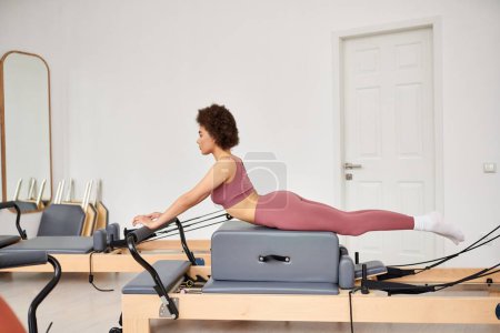 Mujer atractiva haciendo ejercicio durante una lección de pilates.