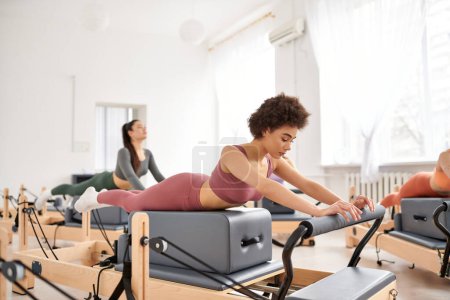 Sporty women practicing in a gym during a pilates lesson.