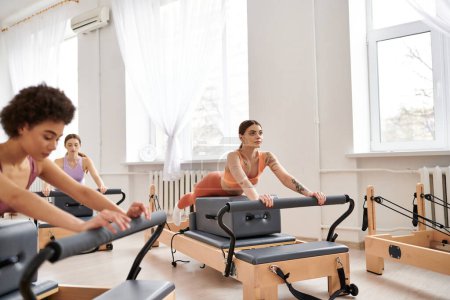 Appealing women in sportswear during pilates in a gym together.
