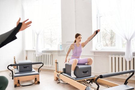 Téléchargez les photos : Femmes sportives en vêtements de sport lors de pilates dans une salle de gym ensemble. - en image libre de droit