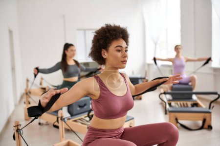 Group of sporty women practicing pilates in a studio.