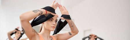 Téléchargez les photos : Une jolie femme sportive avec les mains en l'air pendant une leçon de pilates. - en image libre de droit