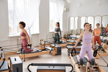 Dynamic women enhancing fitness levels with a Pilates workout session.