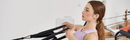 Mujer atractiva practicando activamente mientras en la lección de pilates.