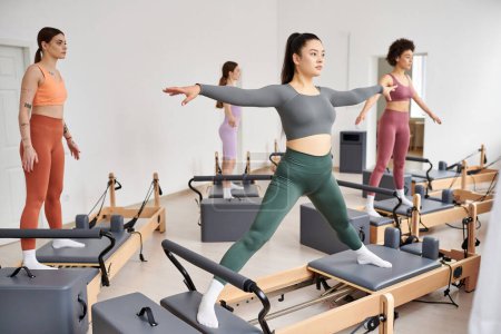 A diverse group of sporty women engaging in a dynamic pilates class full of energy and movement.