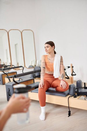 Athletic women spending time together on pilates lesson in gym, relaxing.