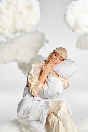 Una mujer rubia soñadora en pijama acogedor se sienta pacíficamente sobre nubes esponjosas.