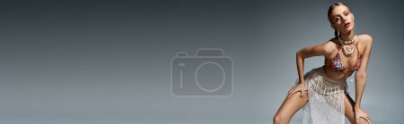Foto de Mujer rubia de moda posando elegantemente sobre un fondo gris. - Imagen libre de derechos