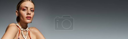 Téléchargez les photos : Femme blonde à la mode frappant une pose tout en mettant en valeur un magnifique collier. - en image libre de droit