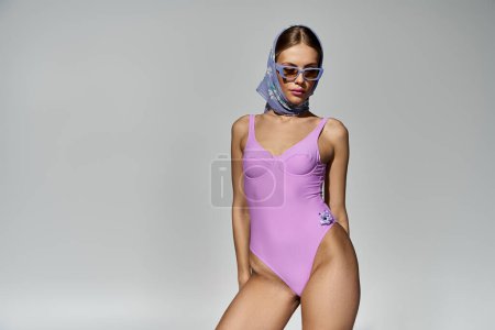 Stilvolle Frau im lila Badeanzug in Pose.