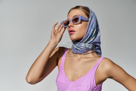 Téléchargez les photos : Une femme à la mode portant des lunettes de soleil et une écharpe. - en image libre de droit