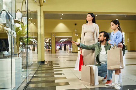 Una familia feliz examina sus bolsas de la compra en un centro comercial ocupado durante una excursión de fin de semana llena de diversión.