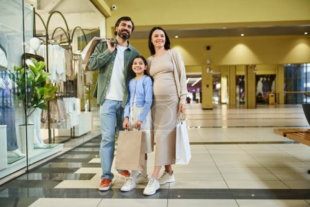 Une femme enceinte et sa jeune fille profitent d'une promenade tranquille dans un centre commercial animé, partageant des moments spéciaux ensemble.