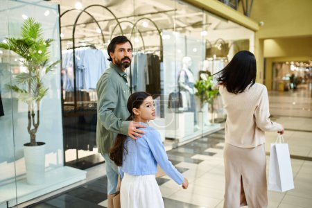 Téléchargez les photos : Un homme et sa fille profitent d'une promenade tranquille dans un centre commercial animé lors d'un week-end en famille heureux. - en image libre de droit