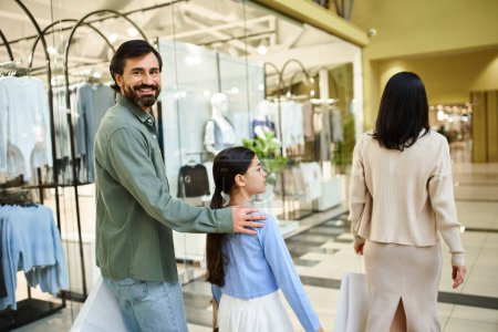 A joyful father and his daughter browse through stores in a bustling shopping mall during a fun weekend outing.