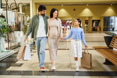 Una familia feliz camina a través de un centro comercial ocupado, llevando bolsas llenas de compras.