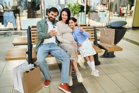 Une famille heureuse assise ensemble sur un banc dans un centre commercial animé, profitant d'une sortie de week-end.