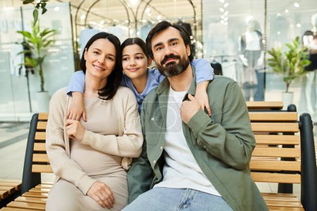 Eine fröhliche Familie entspannt sich auf einer Bank in einem belebten Einkaufszentrum und genießt einen Moment des Zusammenseins inmitten des Trubels.