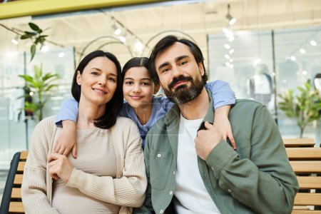 Eine fröhliche Familie macht eine Pause auf einer Bank, während sie einen gemeinsamen Einkaufsbummel in einem Geschäft genießt.
