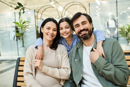 Una familia alegre se sienta en un banco en un vibrante centro comercial, disfrutando de un momento compartido en medio de su excursión de fin de semana.