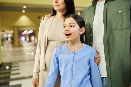 Téléchargez les photos : Une famille heureuse profite d'un week-end shopping au centre commercial avec leur fille. - en image libre de droit
