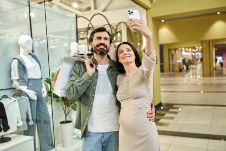 Ein freudiges Paar umarmt sich inmitten eines belebten Einkaufszentrums für ein Selfie und fängt ihre gemeinsamen Glücksmomente ein.