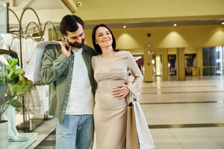 A pregnant woman and man enjoy a leisurely walk through a vibrant shopping mall on a relaxing weekend day.