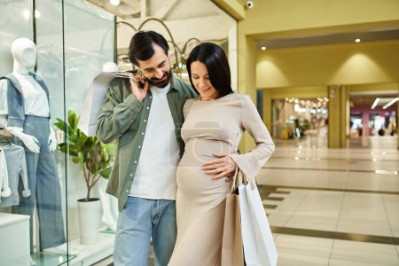 A pregnant man and woman happily shop together in a bustling mall, enjoying their time as a growing family.