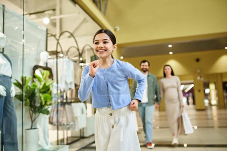 Kind joggt energisch durch ein belebtes Einkaufszentrum, umgeben von Geschäften und Menschen.