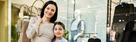 Eine Frau und ihre Tochter genießen gemeinsam ein Einkaufswochenende und erkunden ein belebtes Einkaufszentrum mit einem Lächeln im Gesicht.