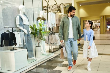 Foto de Un hombre y una chica caminando felices juntos en un bullicioso centro comercial en una juerga de compras de fin de semana. - Imagen libre de derechos