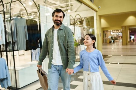 A man and his daughter enjoy a leisurely walk through a bustling shopping mall on a weekend outing.