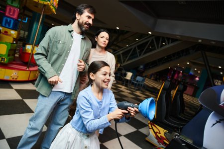 A happy family playing a game in an arcade, sharing laughs and excitement during their weekend outing.