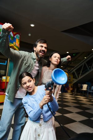 Foto de Una familia alegre se reúne, sosteniendo un megáfono y difundiendo alegría durante su excursión de fin de semana. - Imagen libre de derechos