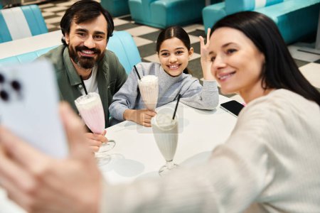 A joyful family captures a selfie in a restaurant, bonding and cherishing quality time together during the weekend.