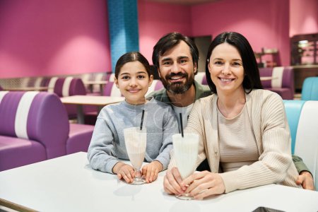 A happy family sits together at a restaurant table, enjoying a quality time during the weekend.