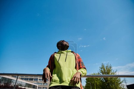 Photo for Stylish African American man looks up at the sky in contemplation. - Royalty Free Image